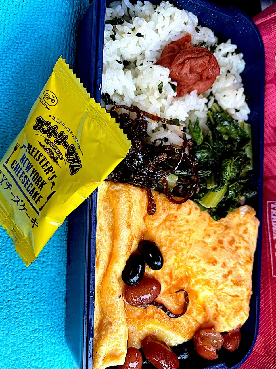 #昼飯　豆と子持ち昆布の天パー顔チーズオムレツと小松菜炒めと梅と黒豆4個茶豆4個乗せワカメ胡麻油風味混ぜご飯カントリーマアムNYチーズケーキ添え弁当|ms903さん