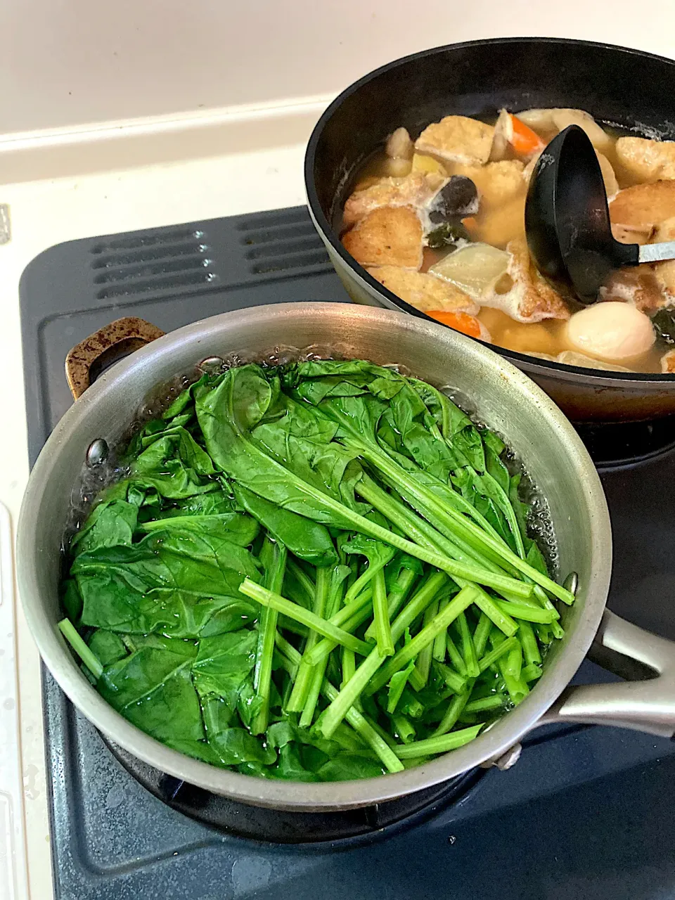 お刺身とおでんのほかに栄養と腸活にいいものがもう一品欲しくて、折角、今日は美味しい日本酒を飲むのだから、いつもの冷やしトマトじゃつまらないので、ほうれん草の胡麻よごしを作ります　根菜おでんをフライパンに移して小鍋が空いたので、鍋いっぱいの水を沸かし、ほうれん草を茹でます（実況中継中）|なびさん