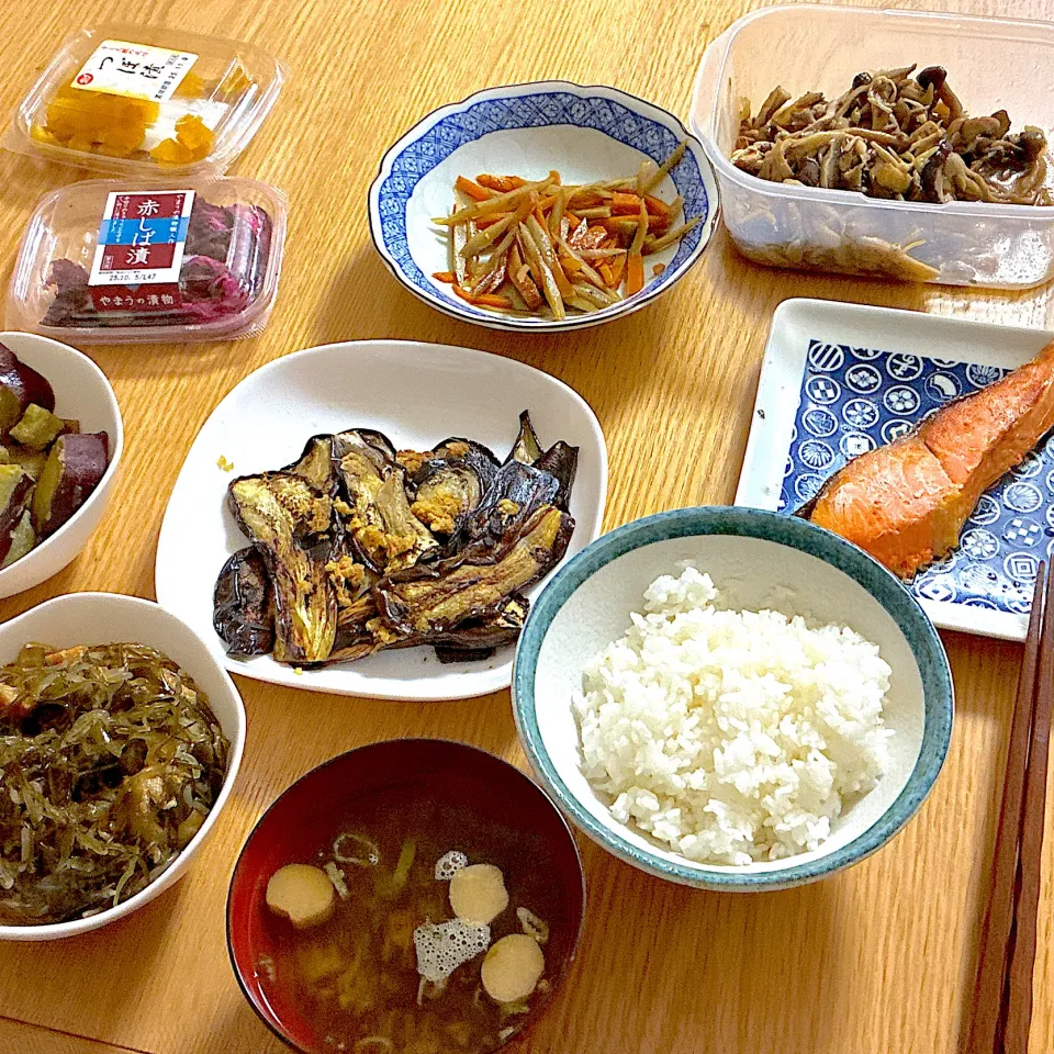 鮭の塩焼き、糸昆布とさつま揚げのだし煮、さつまいもの甘辛煮、きんぴらごぼう、わかめとお麩のお味噌汁、薄切り茄子の生姜焼き、きのこのピリ辛マリネ、しば漬け、つぼ漬け。|くろーぶやんさん