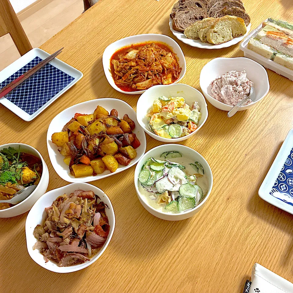 チキンとレンズ豆のスパイスカレー、厚切りベーコンとアーリーレッド粒マスタード醬油炒め、豚キムチ、ジャーマンポテト、大人のポテトサラダ、ドライフルーツ入りバケット、きのこマリネ、さきイカと胡瓜の明太マヨ柚子胡椒和え。|くろーぶやんさん
