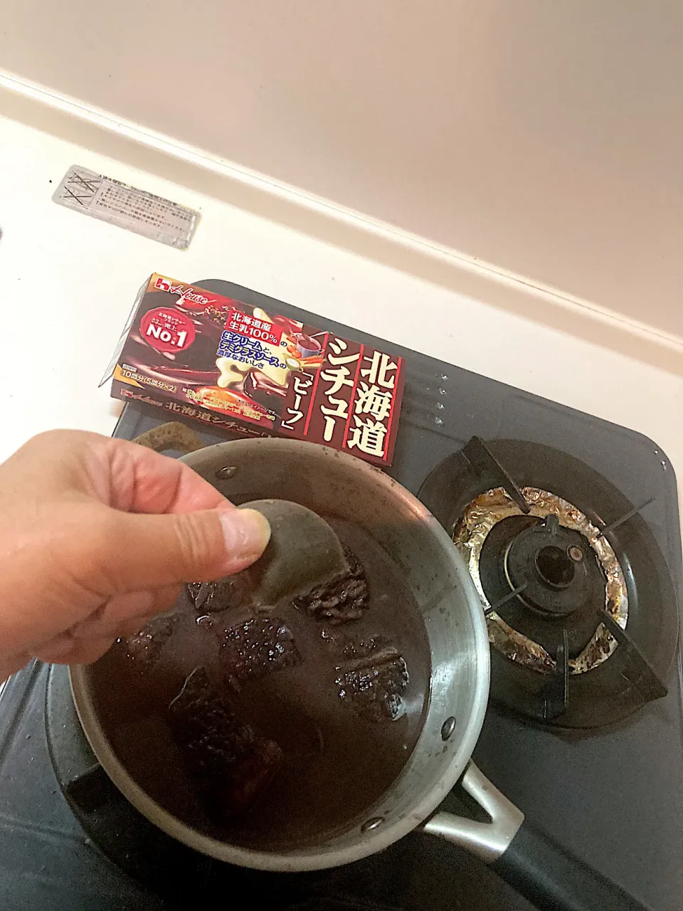 濾した煮汁に肉を戻し、とろみをつけるとともに味にまるみをつけるためハウス「北海道シチュー（ビーフ）」を一かけ加えてもう一煮立ちさせます（実況中継中）|なびさん