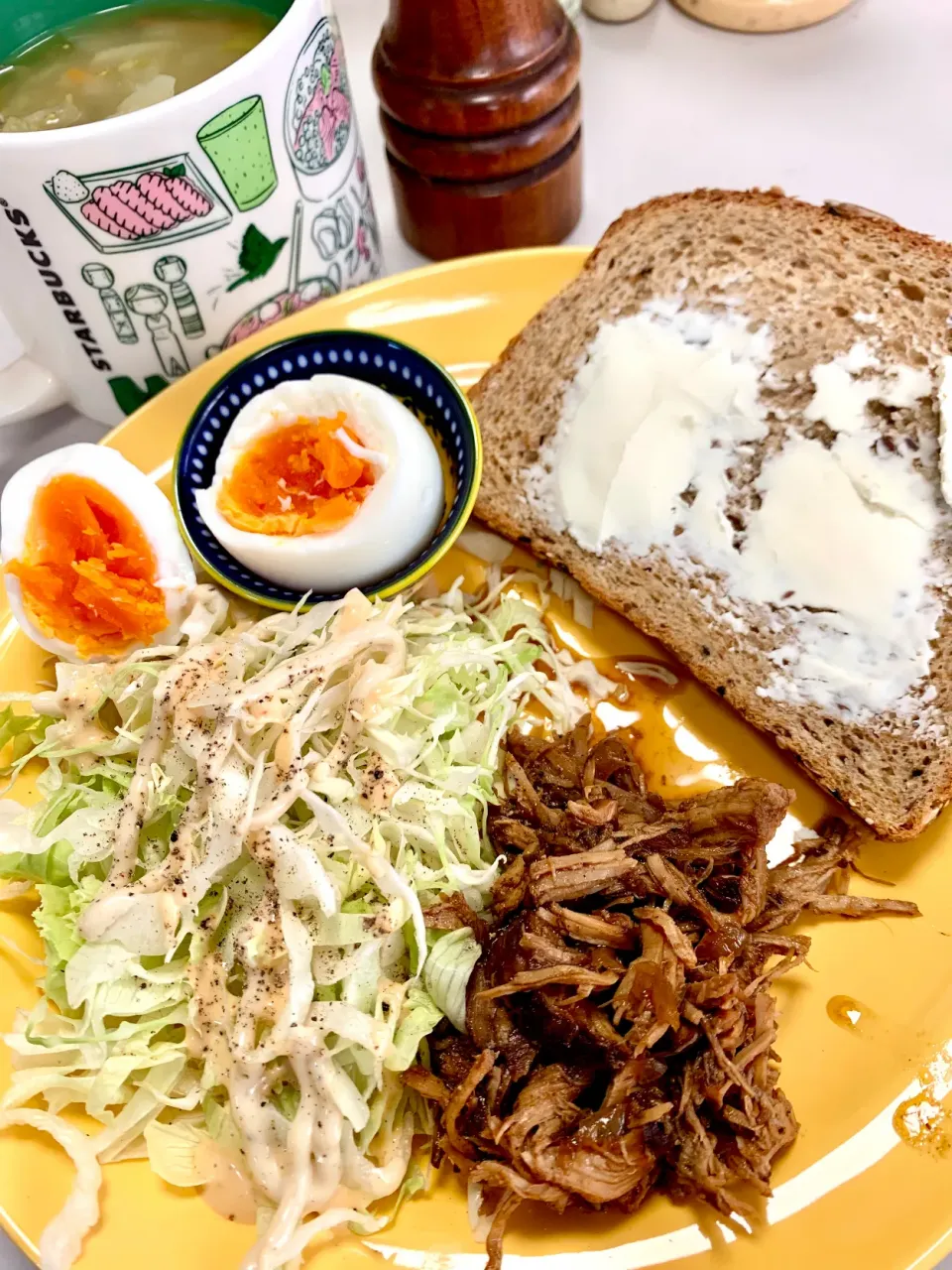Pulled pork, boiled egg, julienned iceberg lettuce, Tuscan vegetable soup and a slice of multigrain bread|gonbenさん