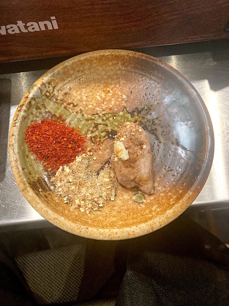 今日の晩ご飯@「トンジスカン  豚都」さん　焼き上がったお肉をスタッフのお兄さんおすすめのスパイスにつけていただきます（実況中継中）|なびさん