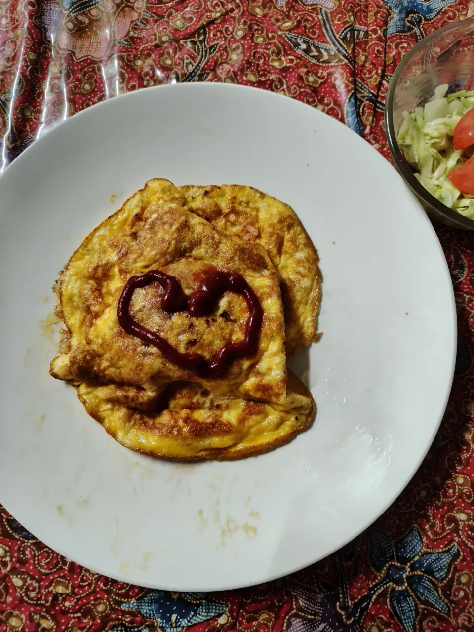 オムライス　熱したフライパンに溶き卵を広げ底が少し固まったらトマトライスをいれて皿にひっくり返す。|はやとさん