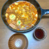 今日の晩ご飯　辛ラーメンのスープを使ったおこしもの入りスパムと根菜のチゲ鍋・たっぷりのとろけるチーズと生卵のせ
