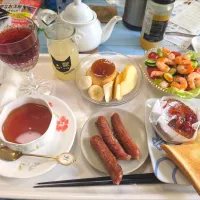5/7（木）遅い朝食、アルコール付き(^^;)。トーストとガトーナンテ。ソーセージ。シュリンプカクテルのサラダ。プリンとりんごバナナ。紅茶。スパークリング赤ワインの炭酸割り。